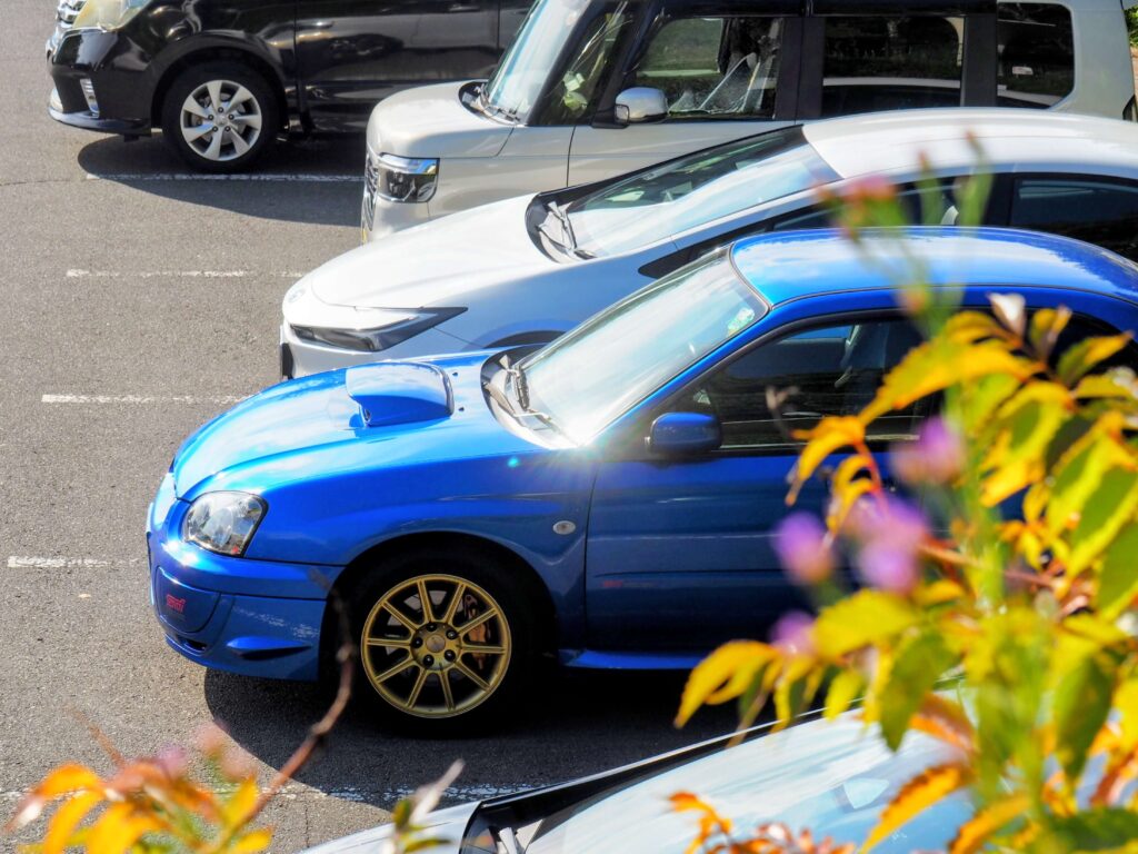 駐車場に停まっている青いスバル・インプレッサ WRX STI(GDB)